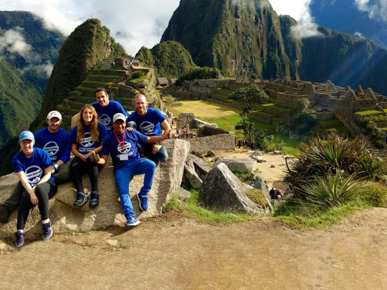 Group of hikers in matching T-shirts at Machu Picchu after the Classic Inca Trail