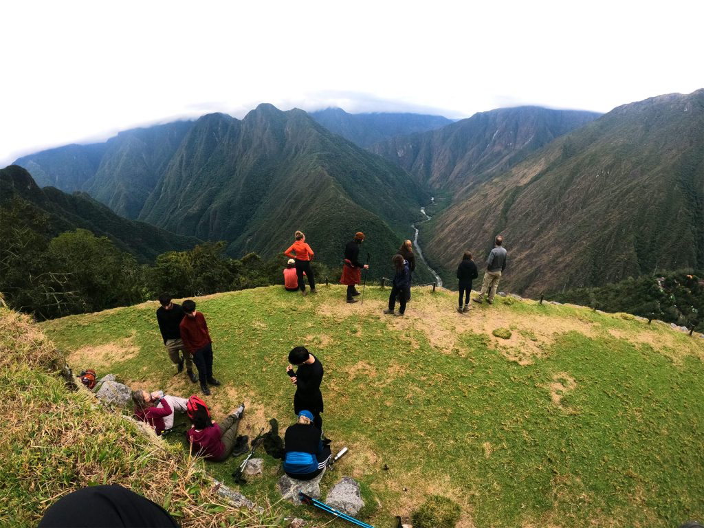 Inca Trail in July 2027: Weather, the Busiest Week and How to Plan Around It 1 A group of hikers resting on a grassy viewpoint above deep green valleys on the Classic Inca Trail