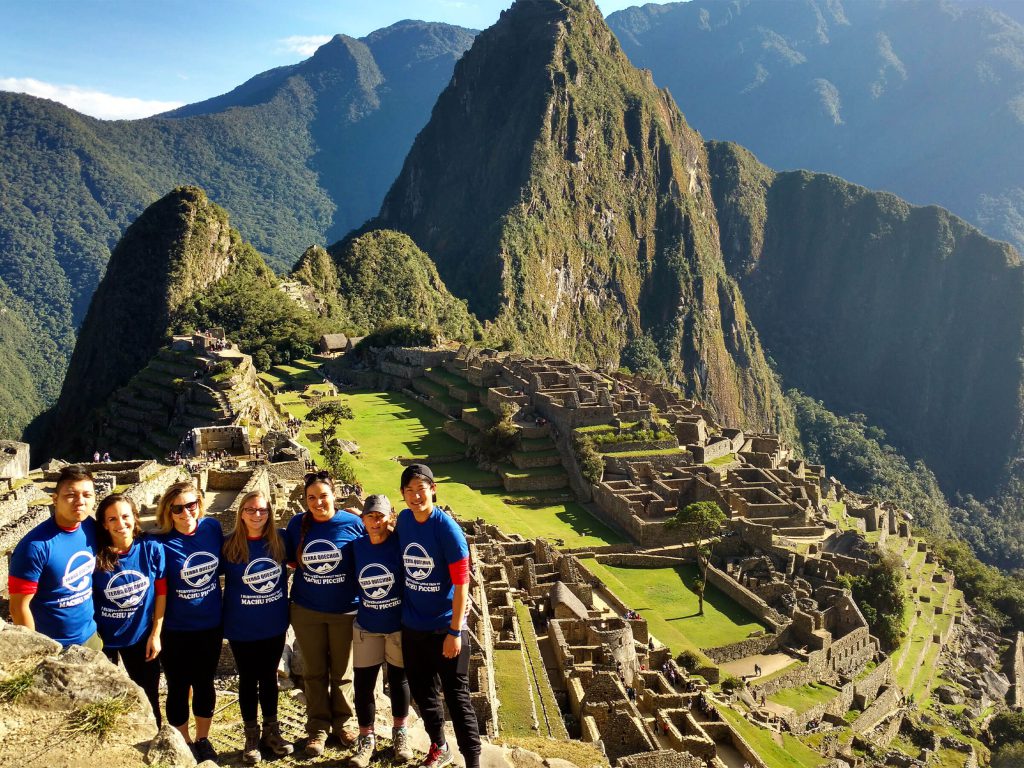 How to Choose a Reputable Inca Trail Operator: A 10-Minute Check for 2027 1 Group of hikers in Terra Quechua t-shirts at Machu Picchu with Huayna Picchu behind them