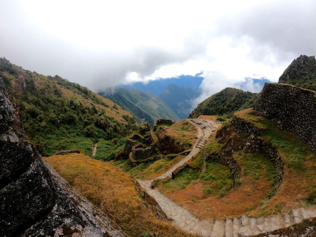 How Hard Is the Inca Trail? Altitude, Dead Woman’s Pass and How to Prepare 2 Stone stairway of the Inca Trail descending past the ruins of Phuyupatamarca between clouds