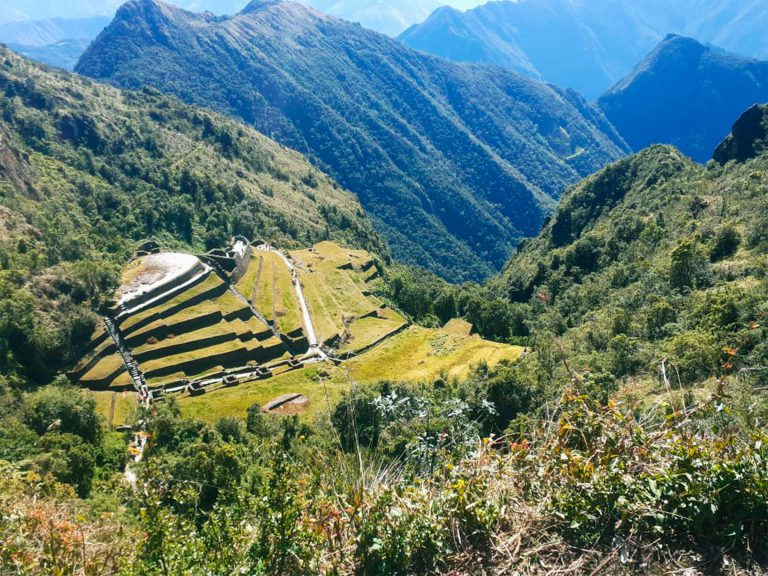 Inca terraces on a green mountainside along the Classic Inca Trail under a sunny sky