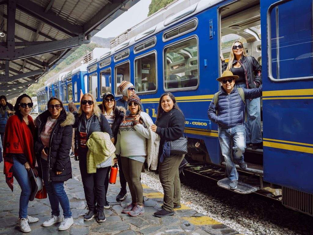 Inca Trail Cost 2027: What’s Included, the Extras Nobody Lists and Your Real Total 2 Group of travelers next to the tourist train on the Ollantaytambo–Aguas Calientes line