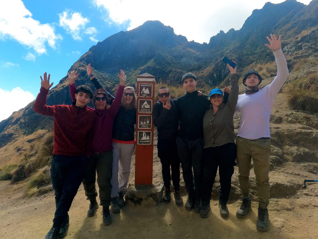 Inca Trail vs Kilimanjaro: Which Is Harder? The Numbers Side by Side 1 Hikers celebrating at the Dead Woman's Pass sign, 4,215 m, on the Classic Inca Trail