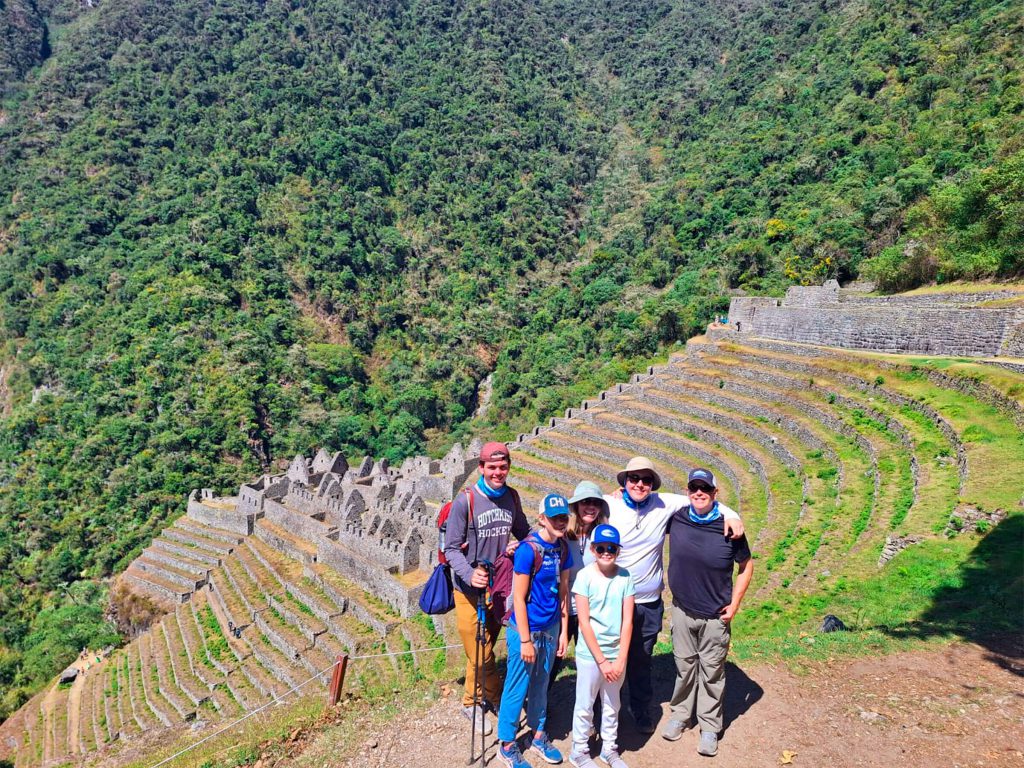 Family of hikers in front of the Inca terraces of Wiñay Wayna on the Inca Trail