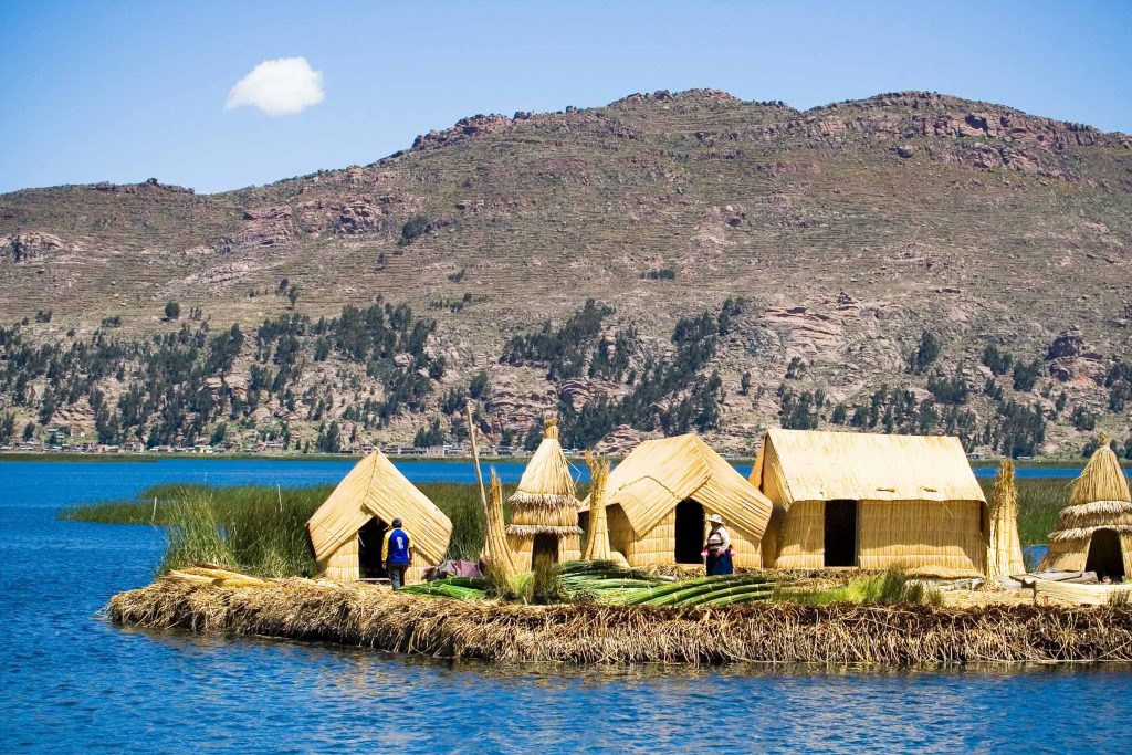 Puno’s “Fertility Temple” Without the Myths: What Inca Uyo Really Is 3 Reed houses on a floating Uros island on Lake Titicaca with hills behind