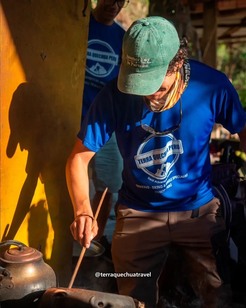 Guide roasting coffee beans in a pan over a wood fire on the Inca Jungle trek