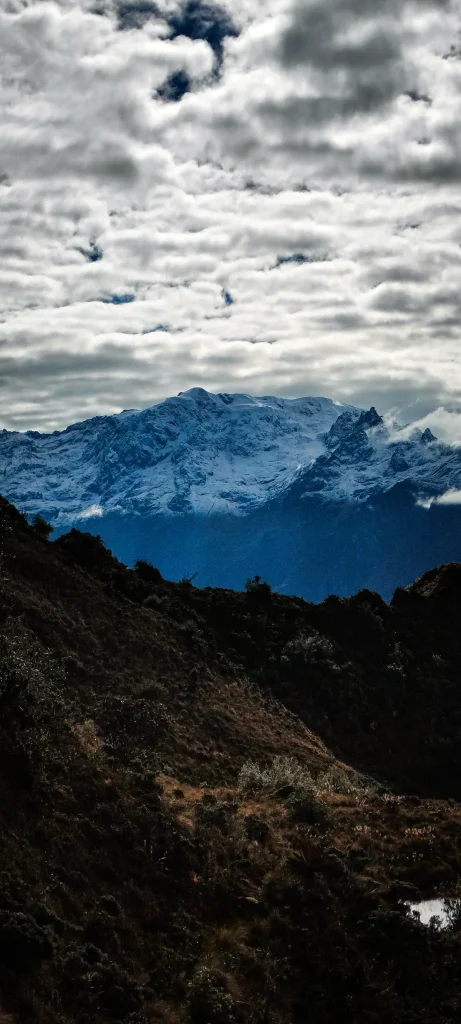 Snow-capped mountain under dramatic clouds seen from the Inca Trail