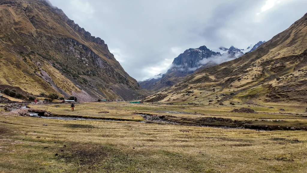 Morning in a wide grassy valley with snow peaks on the Lares trek