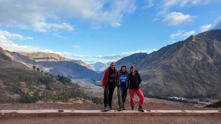 Group of hikers posing at a viewpoint with mountains behind on the Lares trek