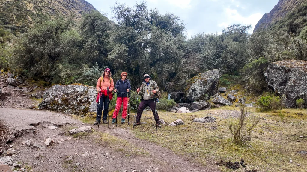 Three hikers standing in a native Andean forest on the Lares trek