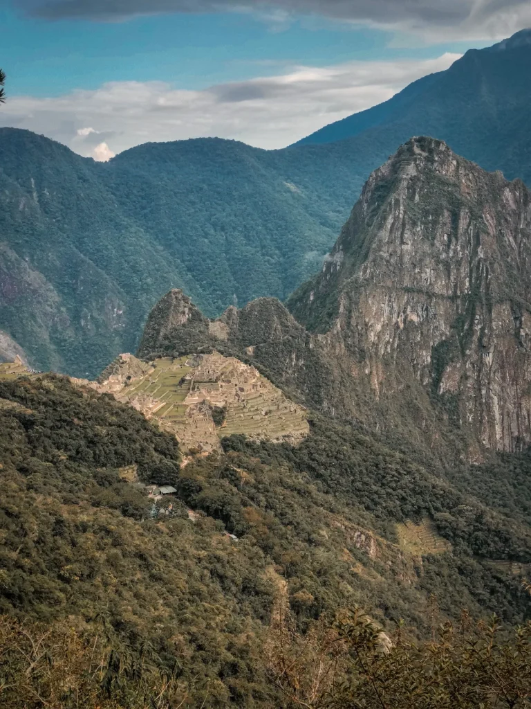Machu Picchu citadel and Huayna Picchu framed by green mountains, seen from the Inca Trail