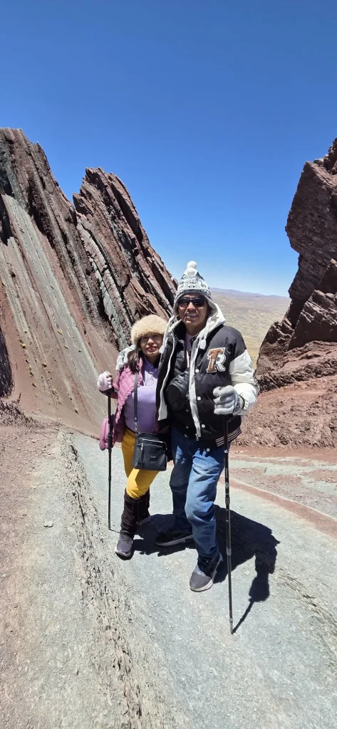 Couple with trekking poles on the trail between the striped rock fins of Pallay Punchu
