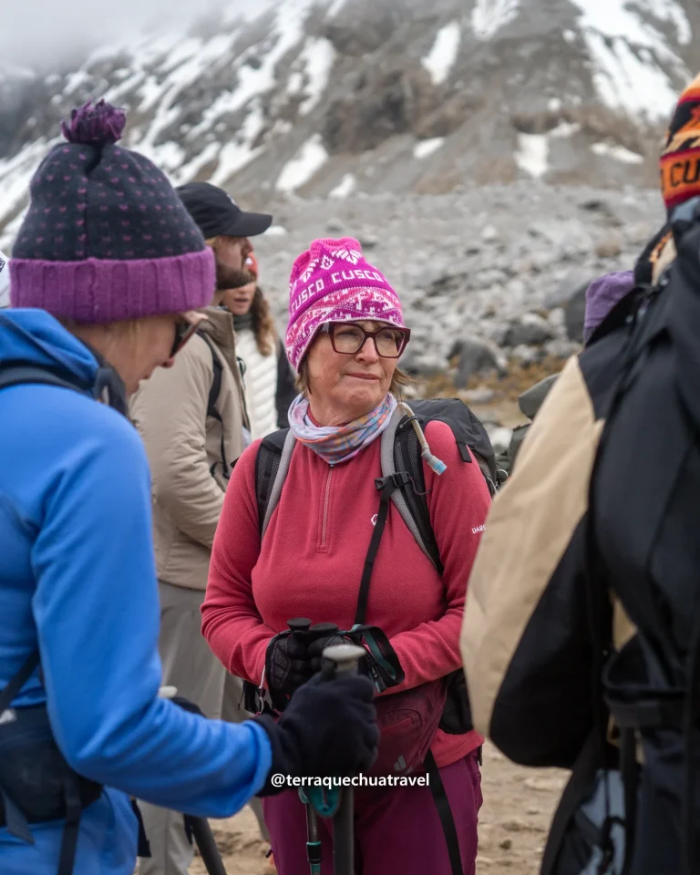 Hikers in warm hats and gloves with snowy mountains behind on the Salkantay trek
