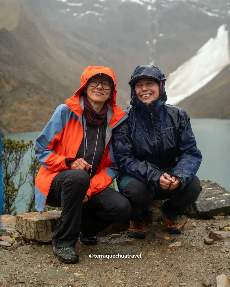Two hikers in rain jackets at Humantay Lake on the Salkantay trek