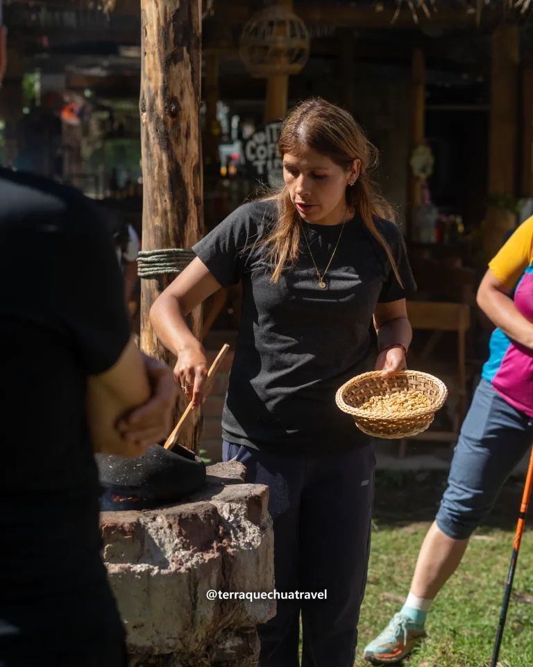 Hiker roasting coffee beans in a clay pot with a basket of beans on the Salkantay trek
